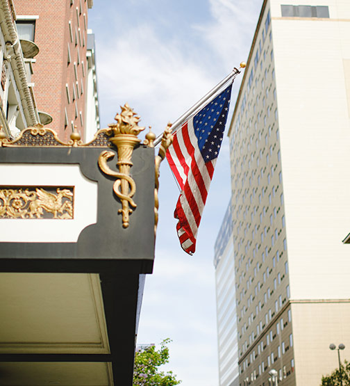 American flag hanging from a pole outside a building in Boston
